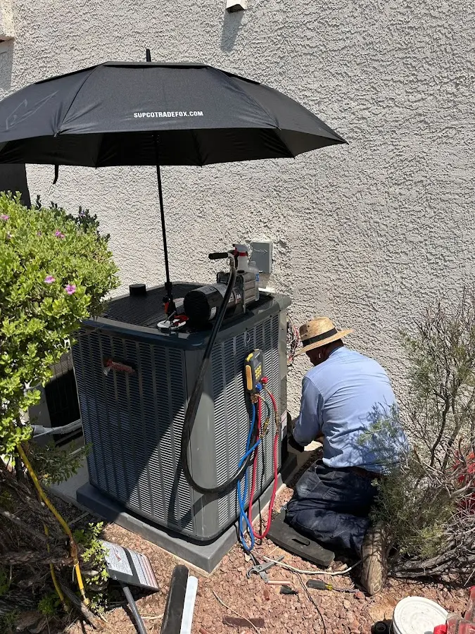 HVAC technician performing outdoor AC maintenance in Ellwood City