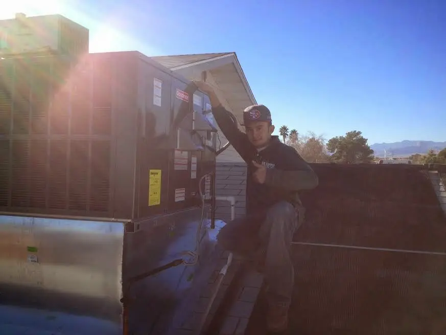 HVAC technician performing Boiler Repair on a rooftop unit in Ellwood City